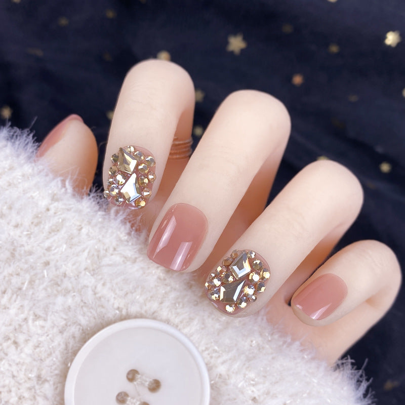 Manicura con parches de diamantes dorados champán y uñas postizas terminadas