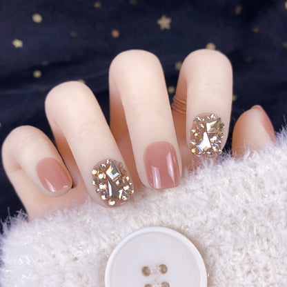 Manicura con parches de diamantes dorados champán y uñas postizas terminadas