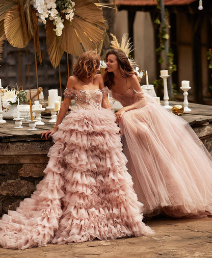 Vestido de novia rosa de una línea con hombros descubiertos y falda de pastel con pedrería y tachuelas de princesa