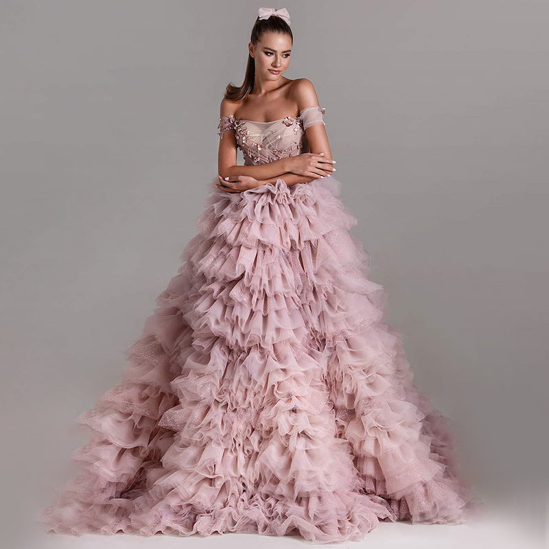 Vestido de novia rosa de una línea con hombros descubiertos y falda de pastel con pedrería y tachuelas de princesa