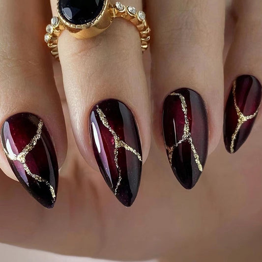 Uñas postizas con patrón de piedra en polvo dorado y rojo oscuro